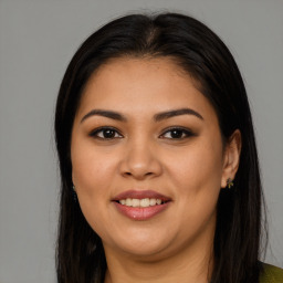 Joyful latino young-adult female with long  brown hair and brown eyes