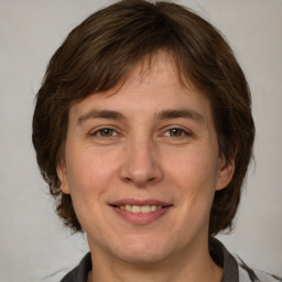 Joyful white adult female with medium  brown hair and grey eyes