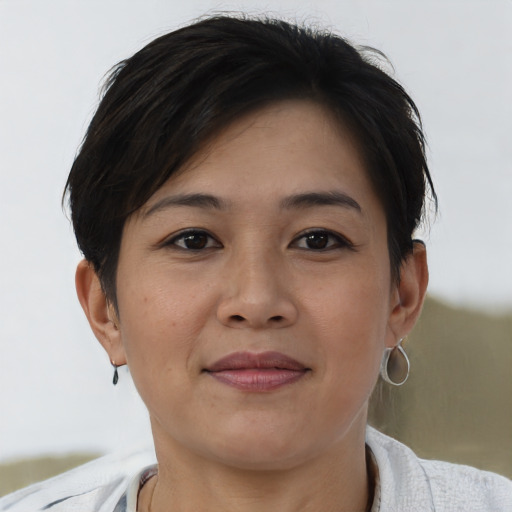 Joyful asian young-adult female with short  brown hair and brown eyes