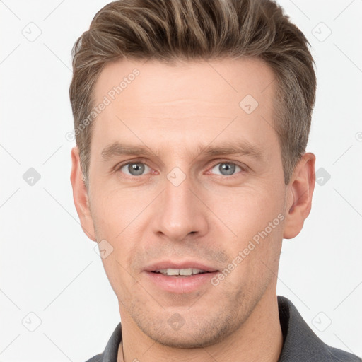 Joyful white adult male with short  brown hair and grey eyes