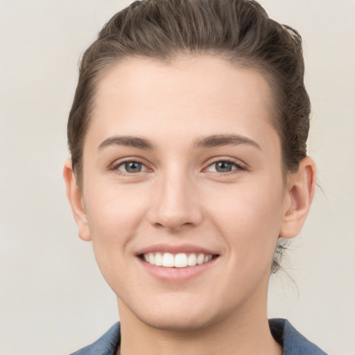 Joyful white young-adult female with short  brown hair and grey eyes