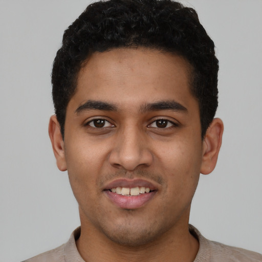 Joyful latino young-adult male with short  black hair and brown eyes