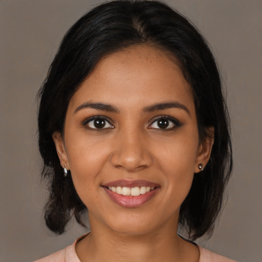 Joyful black young-adult female with medium  brown hair and brown eyes