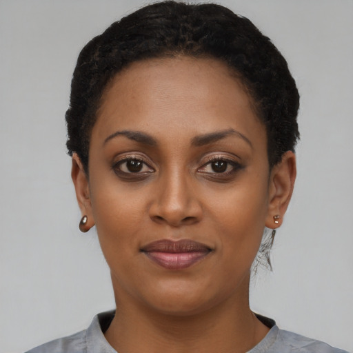 Joyful black young-adult female with short  black hair and brown eyes