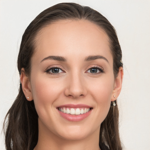 Joyful white young-adult female with long  brown hair and grey eyes