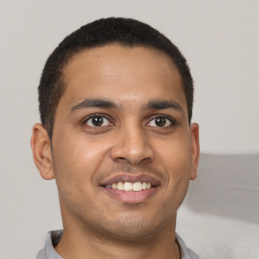 Joyful latino young-adult male with short  brown hair and brown eyes