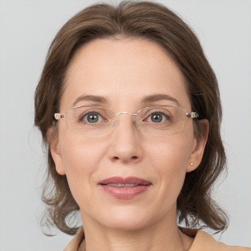 Joyful white adult female with medium  brown hair and grey eyes