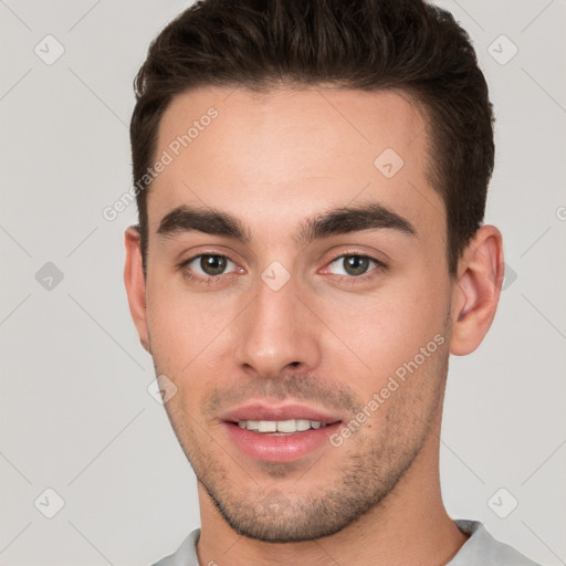 Joyful white young-adult male with short  brown hair and brown eyes