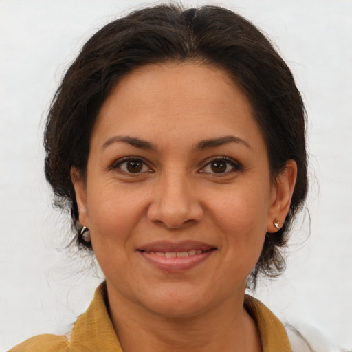 Joyful latino adult female with medium  brown hair and brown eyes