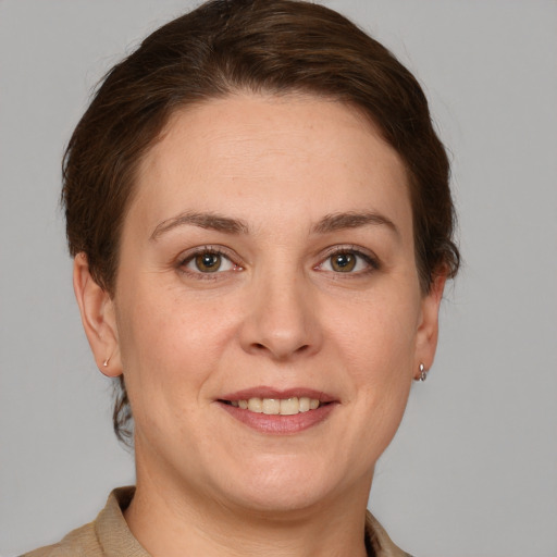 Joyful white young-adult female with short  brown hair and grey eyes