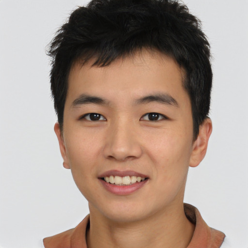Joyful asian young-adult male with short  brown hair and brown eyes