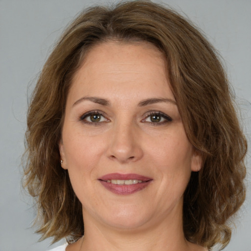 Joyful white adult female with medium  brown hair and brown eyes