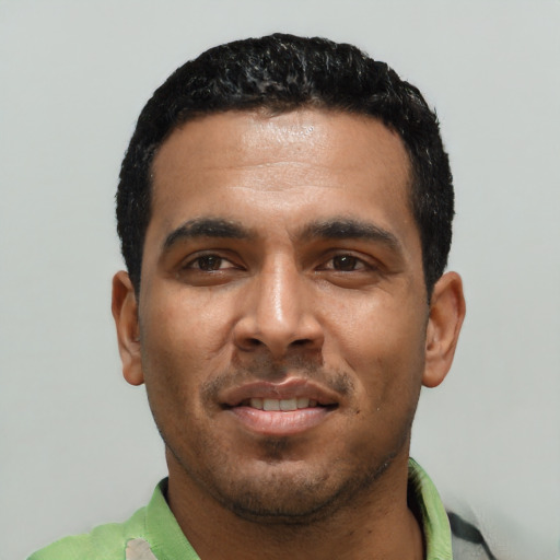 Joyful black young-adult male with short  black hair and brown eyes