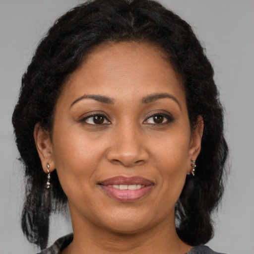 Joyful black adult female with medium  brown hair and brown eyes