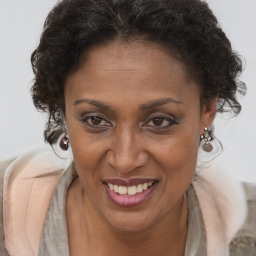 Joyful black adult female with long  brown hair and brown eyes