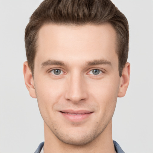 Joyful white young-adult male with short  brown hair and grey eyes