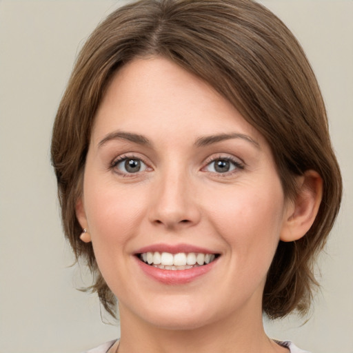 Joyful white young-adult female with medium  brown hair and green eyes