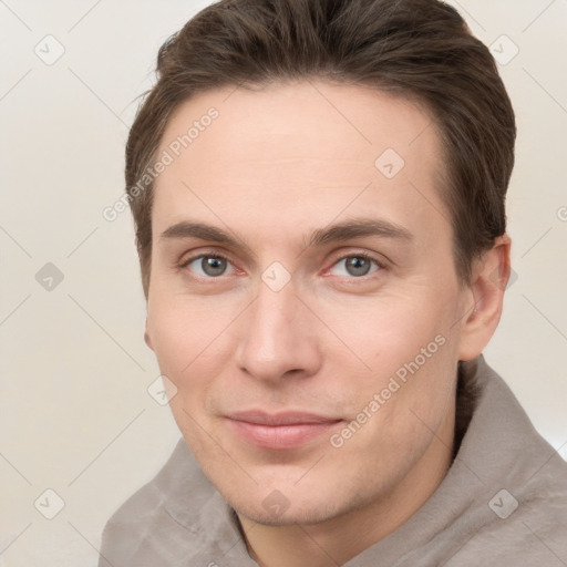 Joyful white young-adult male with short  brown hair and grey eyes