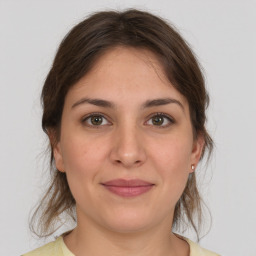 Joyful white young-adult female with medium  brown hair and grey eyes