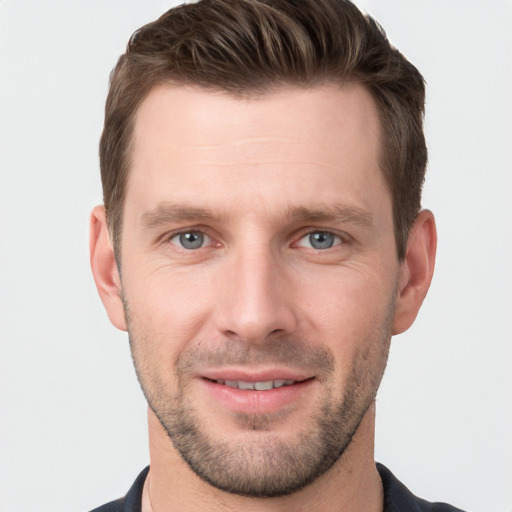 Joyful white young-adult male with short  brown hair and grey eyes