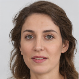 Joyful white adult female with long  brown hair and grey eyes