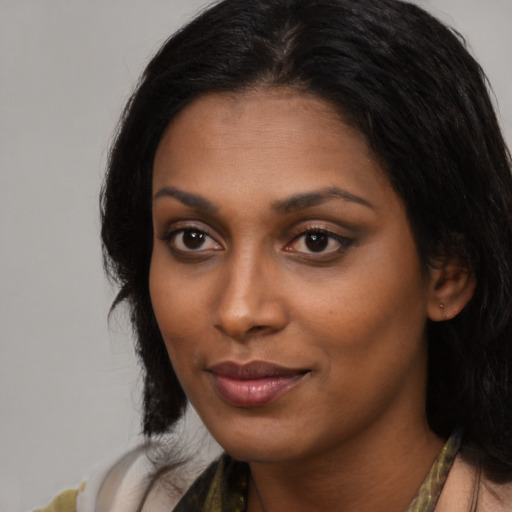 Joyful black young-adult female with long  black hair and brown eyes