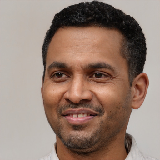Joyful latino adult male with short  black hair and brown eyes
