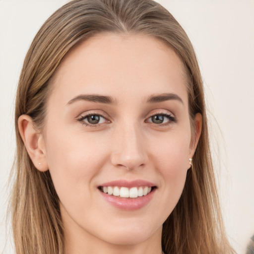 Joyful white young-adult female with long  brown hair and grey eyes