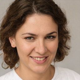 Joyful white young-adult female with medium  brown hair and green eyes