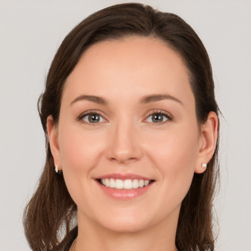 Joyful white young-adult female with medium  brown hair and grey eyes