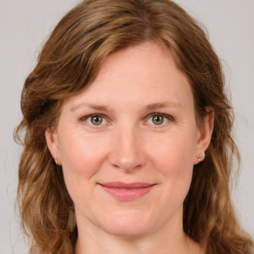 Joyful white adult female with long  brown hair and green eyes