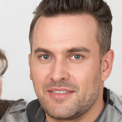 Joyful white adult male with short  brown hair and brown eyes