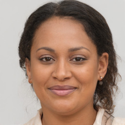 Joyful latino adult female with medium  brown hair and brown eyes