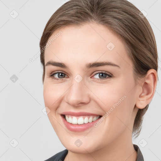 Joyful white young-adult female with medium  brown hair and grey eyes