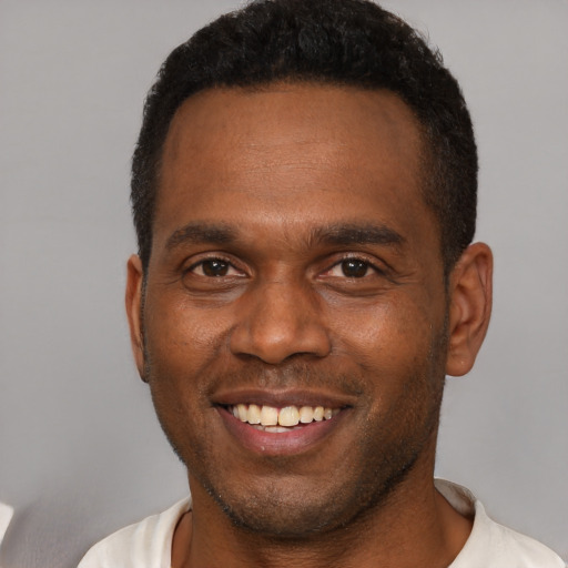 Joyful latino young-adult male with short  brown hair and brown eyes