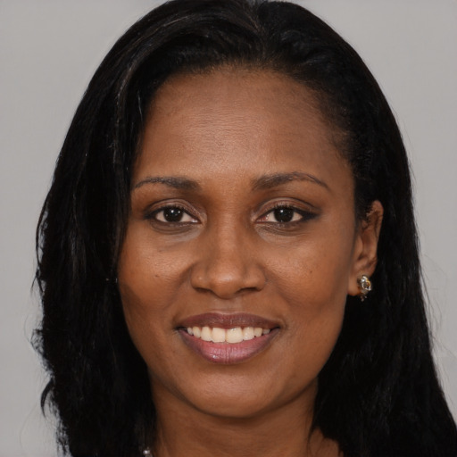 Joyful black young-adult female with long  black hair and brown eyes