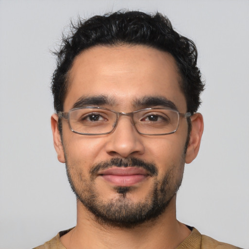 Joyful latino young-adult male with short  black hair and brown eyes