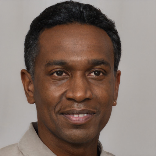 Joyful black adult male with short  black hair and brown eyes