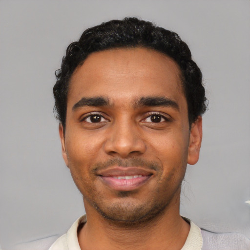 Joyful black young-adult male with short  black hair and brown eyes