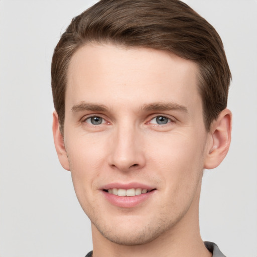 Joyful white young-adult male with short  brown hair and grey eyes