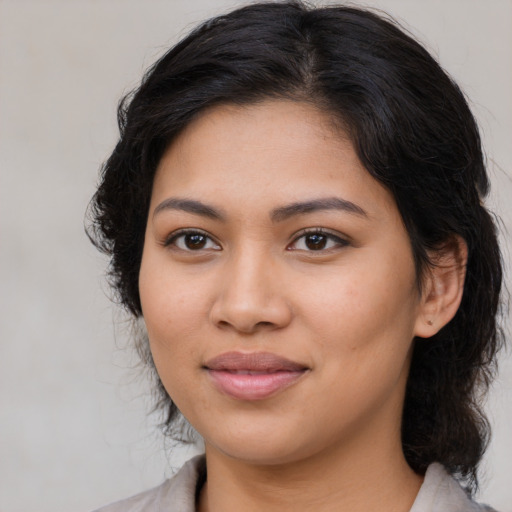 Joyful latino young-adult female with medium  brown hair and brown eyes