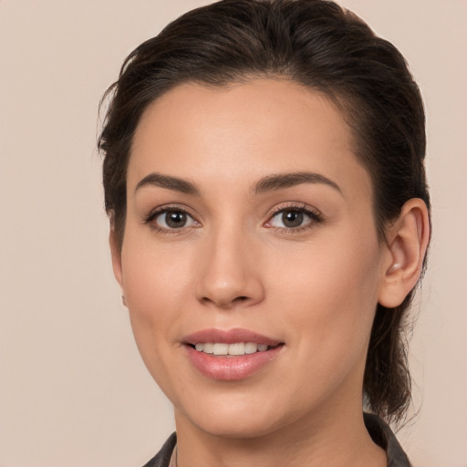 Joyful white young-adult female with long  brown hair and brown eyes