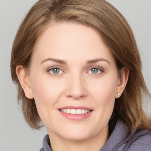 Joyful white young-adult female with medium  brown hair and blue eyes