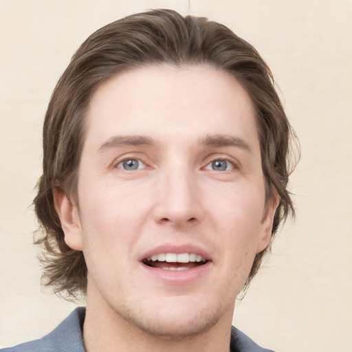 Joyful white young-adult male with medium  brown hair and grey eyes