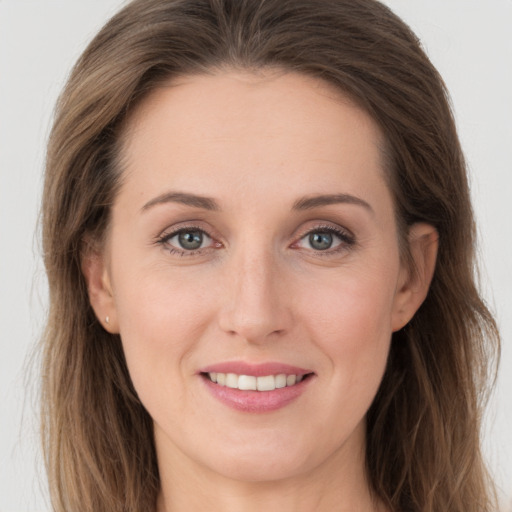 Joyful white young-adult female with long  brown hair and grey eyes