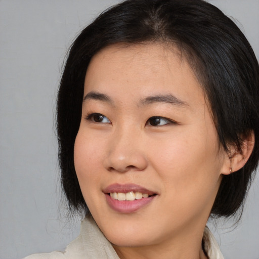 Joyful asian young-adult female with medium  brown hair and brown eyes