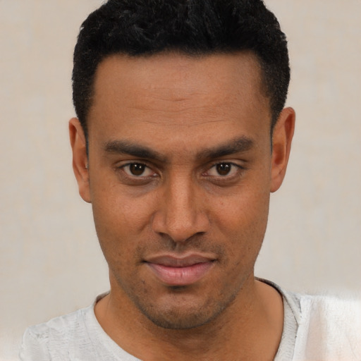 Joyful latino young-adult male with short  black hair and brown eyes