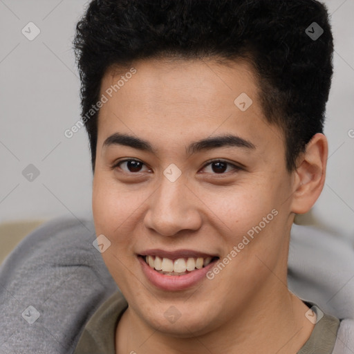 Joyful latino young-adult male with short  brown hair and brown eyes