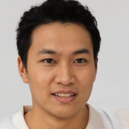 Joyful asian young-adult male with short  brown hair and brown eyes