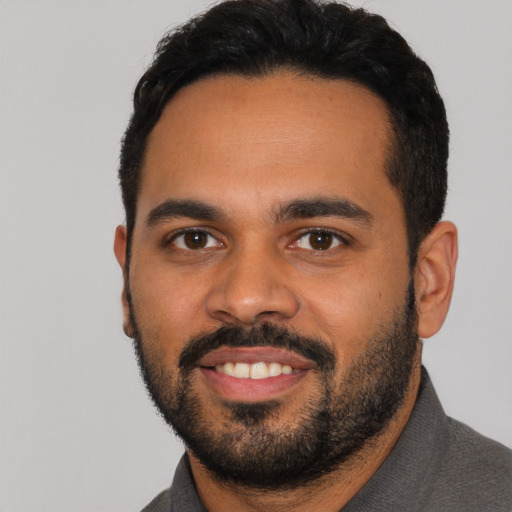 Joyful latino young-adult male with short  black hair and brown eyes
